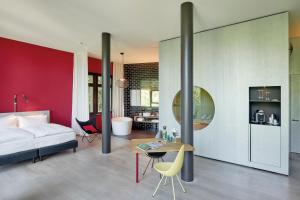 a bedroom with a white bed and a red wall at Sorell Hotel Rigiblick - Studios & Spa Suites in Zürich