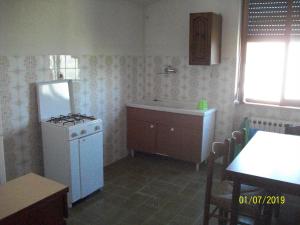 Il comprend une cuisine équipée d'une cuisinière et d'un réfrigérateur blanc. dans l'établissement Sweet Home 2, à Montopoli in Sabina