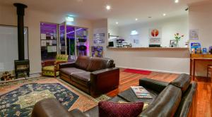 a living room with leather furniture and a bar at Crossroads Ecomotel in Port Augusta