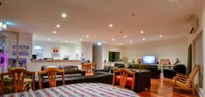 a living room with a couch and chairs and a bar at Crossroads Ecomotel in Port Augusta