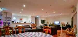 
a living room filled with furniture and a tv at Crossroads Ecomotel in Port Augusta
