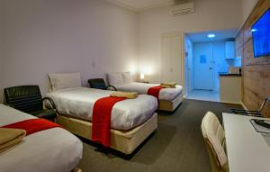 a hotel room with two beds and a television at Crossroads Ecomotel in Port Augusta