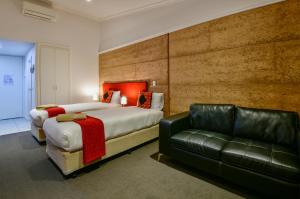 a hotel room with two beds and a couch at Crossroads Ecomotel in Port Augusta +66 photos
