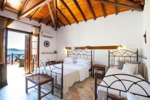 a bedroom with two beds and a balcony at ClubOrsa Chrysoula's Guest House in Skiathos