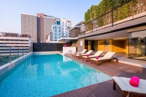 a swimming pool with lounge chairs on a building at GLOW Sukhumvit 5 in Bangkok