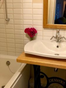 a bathroom with a sink and a vase of flowers at Medus in Ventspils +21 photos