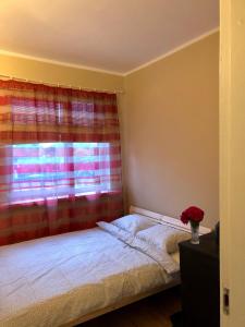 a bedroom with a bed and a window with a curtain at Medus in Ventspils