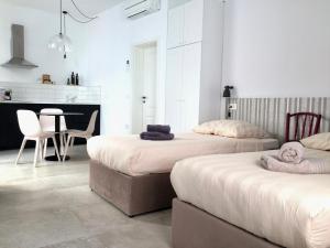 twee bedden in een kamer met een tafel en stoelen bij Casa Bibiana in Koper