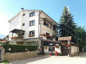 a white building with a christmas tree in front of it at Guest house Tivko Katce Gostivar in Gostivar