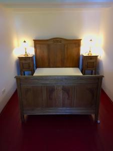 ein Holzbett in einem Zimmer mit zwei Nachttischen in der Unterkunft Freistaat Eifel in Nettersheim