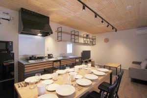 a dining room with a table and a kitchen at Rakuten STAY HOUSE x WILL STYLE Fujiyoshida Matsuyama 101 in Fujiyoshida
