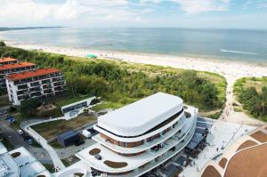 een groot wit gebouw naast een strand bij Baltic Park Molo Apartments by Zdrojowa in Świnoujście