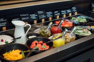 a buffet line with bowls of different types of food at Vienna House Easy by Wyndham Cracow in Kraków