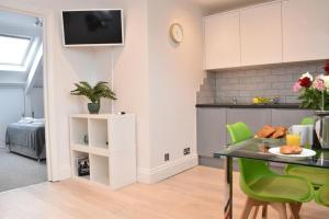 a kitchen and dining room with a table and green chairs at Apt 3, Opera House ensuite 4th Floor by Indigo Flats in London