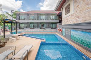 a swimming pool in front of a building at Chayadol Resort - SHA Extra Plus in Chiang Rai