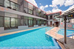 a swimming pool in front of a building at Chayadol Resort - SHA Extra Plus in Chiang Rai