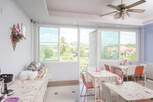 a dining room with tables and chairs and a large window at Chayadol Resort - SHA Extra Plus in Chiang Rai