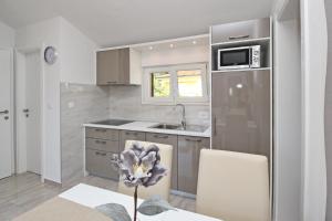 eine Küche mit einer Spüle und einem Kühlschrank in der Unterkunft Sunshine Residence Baska in Baška