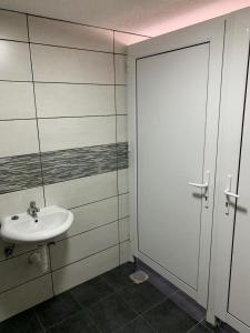 Baño blanco con lavabo y puerta en Guest house Tivko Katce Gostivar, en Gostivar