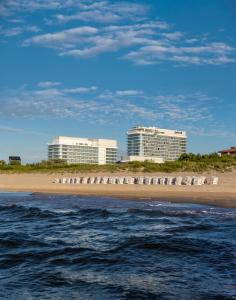 a beach with buildings in the background and the ocean at Radisson Blu Resort Swinoujscie in Świnoujście