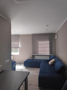 ein Wohnzimmer mit einem blauen Sofa und einem Tisch in der Unterkunft MD Apartments in Jūrmala