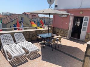 a patio with a table and chairs and an umbrella at Apartments Sunpoint in Ulcinj