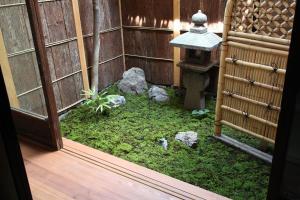 een kleine tuin met mos en rotsen in een gebouw bij Bed & Breakfast Tsukiya in Kyoto