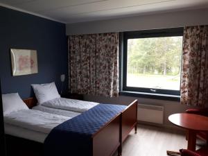 a bedroom with a bed and a large window at Vatnahalsen Høyfjellshotell in Myrdal