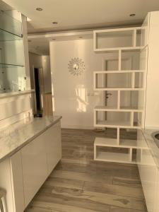 cocina con armarios blancos y suelo de madera en AURA Apartments, en Budva