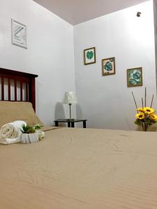 a bedroom with a bed and some pictures on the wall at BUDGET FRIENDLY CONDO-STUDIO UNIT in Cebu City