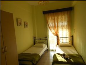 two beds in a room with a window at Villa Marili in Paralia Katerinis