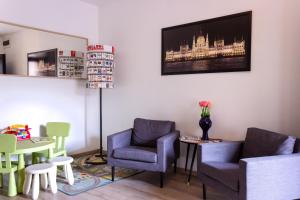 a living room with chairs and a tv on the wall at Budapest Center Residence in Budapest