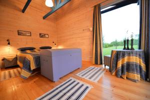 een slaapkamer met een bed en een groot raam bij Kliukai in Dubingiai