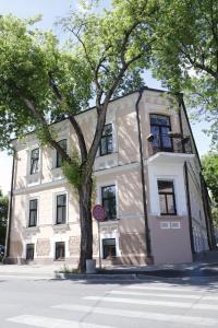 a large white building with a tree in front of it at Apartamenti DVINSKA in Daugavpils