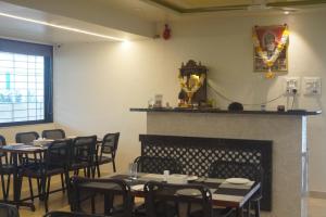 comedor con mesas y sillas y chimenea en Hotel Sai Sharada, en Pune