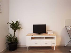 a tv sitting on top of a white dresser at Très bel appartement Centre Vitré in Vitré