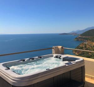 a hot tub on a balcony with a view of the ocean at Blue Horizon Suites in Paralion astros