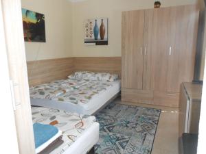 ハイドゥソボスローにあるZsóka apartmanのベッドルーム1室(ベッド2台、キャビネット付)