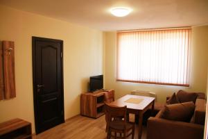 a small living room with a table and a couch at Хотел АЛЕКСАНДЪР in Pavel Banya