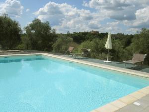 a swimming pool with two chairs and a umbrella at Agriturismo La Torretta in Siena