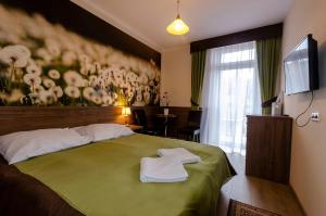 a bedroom with a large green bed with a painting on the wall at Sanatorium Energetyk in Krynica Zdrój