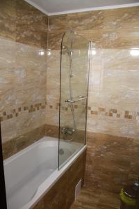 La salle de bains est pourvue d'une baignoire et d'une douche. dans l'établissement Хотел АЛЕКСАНДЪР, à Pavel Banya