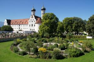 un giardino di fronte a un grande edificio bianco di Zentrum für Umwelt und Kultur - Gästehaus und Jugendbildungseinrichtung im Maierhof a Benediktbeuern