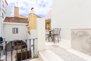 a balcony with a table and chairs in a building at Archi-Pelago Alfama Design Suites Guesthouse in Lisbon