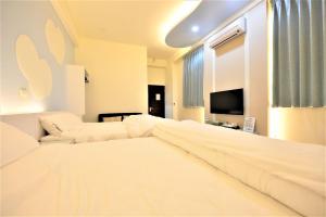sypialnia z dużym łóżkiem i telewizorem w obiekcie 日晴民宿 Sun Day w mieście Magong