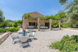 a patio with a table and chairs in front of a building at Puig De Garrafa 6 in Andratx