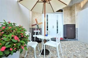 patio ze stołem, krzesłami i parasolem w obiekcie 日晴民宿 Sun Day w mieście Magong