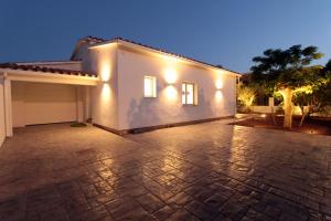una casa bianca con luci su un vialetto di mattoni di LEON INMO Villa Magna - 12262 a Empuriabrava