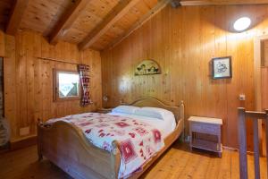 a bedroom with a bed in a log cabin at Baita Tomaselli in Pellizzano