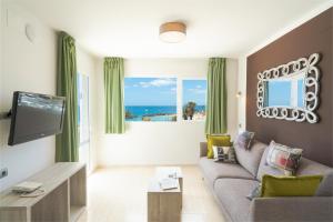 a living room filled with furniture and a tv at Apartamentos Galeon Playa in Costa Teguise